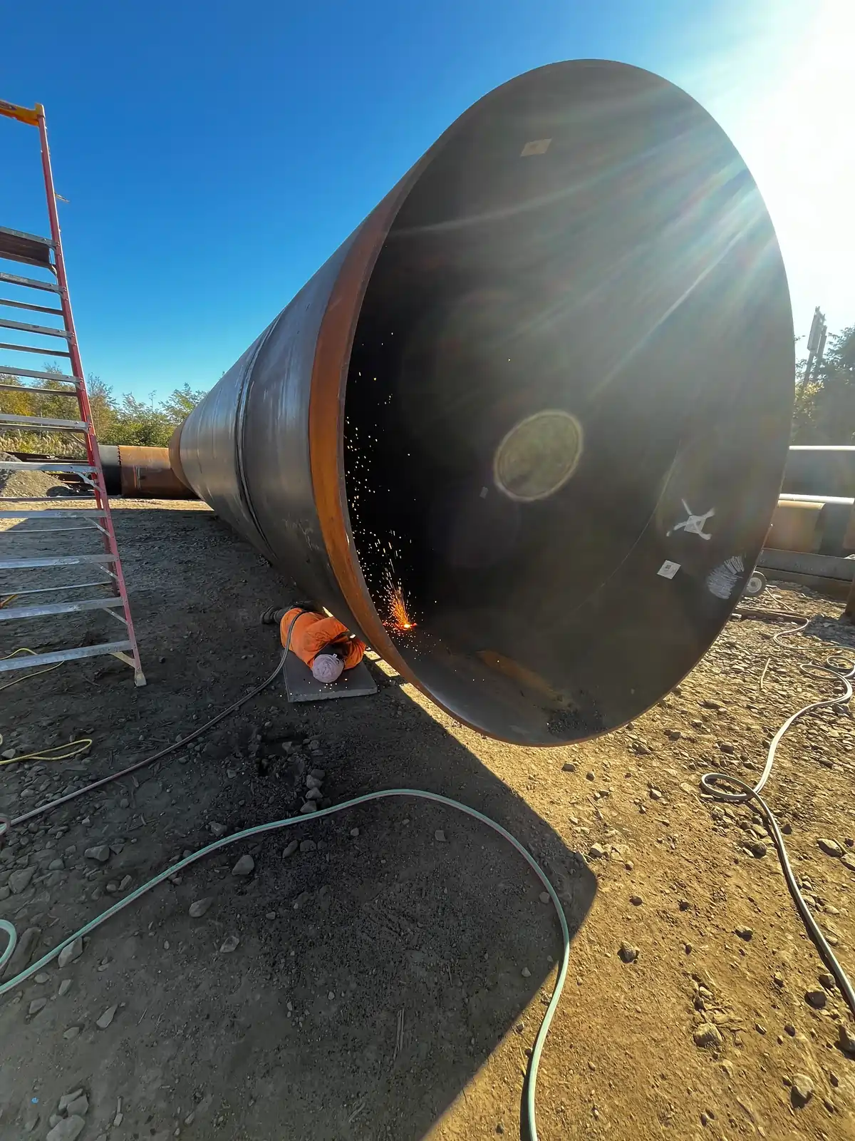 Welder working inside a large-diameter steel pipe